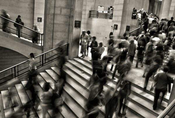 People moving along a busy stairway, in black and white
